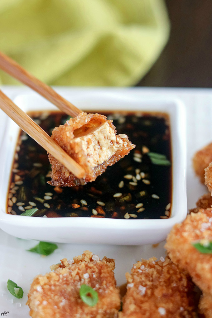Crispy Pan Fried Tofu - Karyl's Kulinary Krusade Tofu piece with bite taken out, in dipping sauce