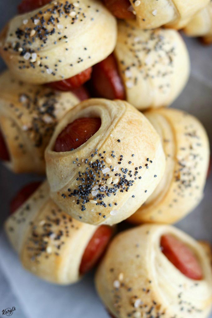 close up shot of stack of pigs in a blanket on parchment paper