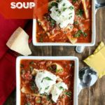overhead shot of 2 white bowls with venison lasagna soup topped wtih ricotta