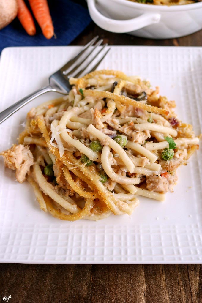 close up angle shot of a scoop of Tuna Tettrazini on a white plate, with a metal fork angled on the plate