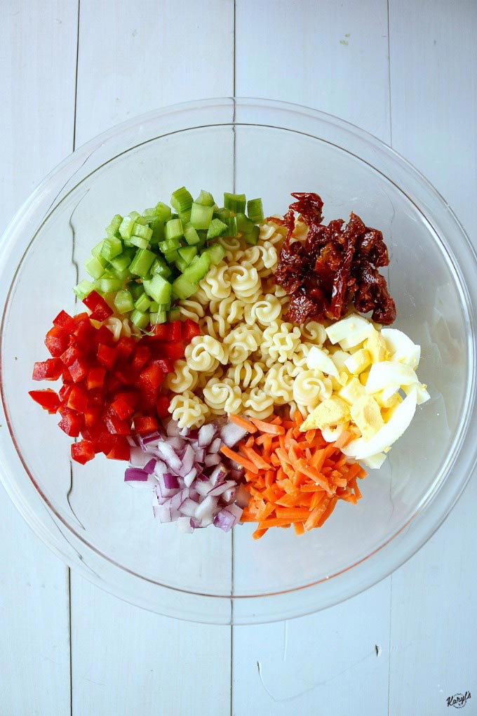 macaroni salad ingredients in a clear bowl