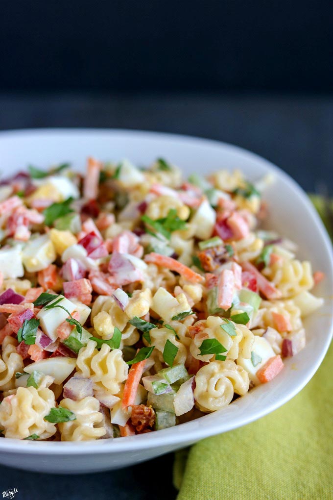 off-center shot of finished macaroni salad in a white bowl
