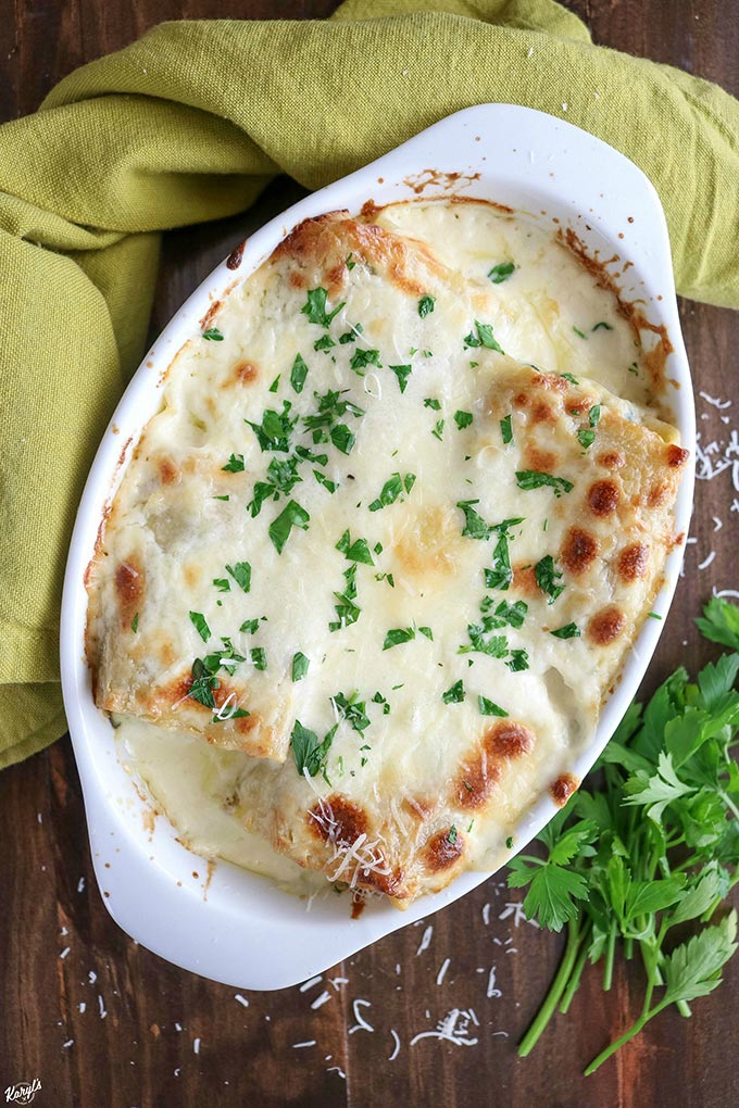 overhead shot of finished spinach alfredo lasagna roll ups in a white casserole dish