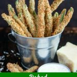 close up shot of Baked Green Bean Fries in a metal bucket with a side of ranch and a chunk of parmesan cheese