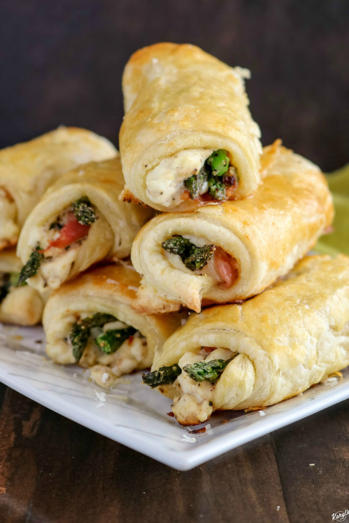 finished Asparagus Prosciutto Puff Pastry stacked on serving dish, open ends showing inside filling