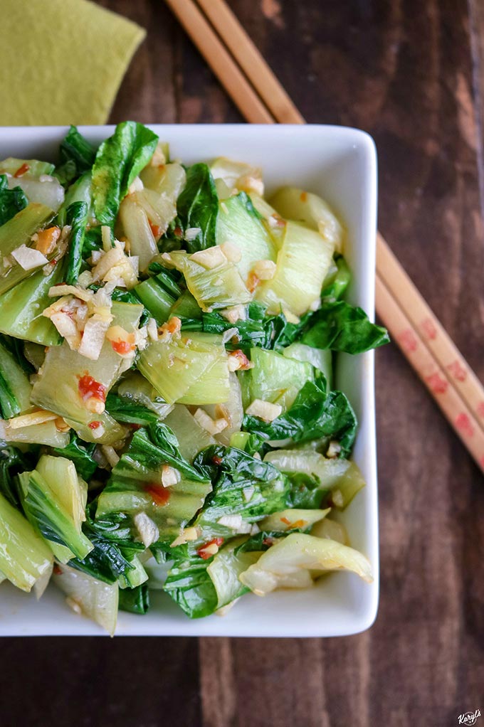 Overhead shot of finished Chili Garlic Baby Bok Choy; bowl off-set to left side