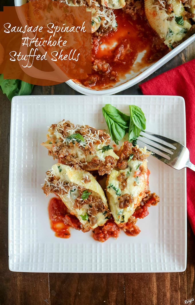 overhead shot of finished Sausage Spinach Artichoke Stuffed Shells on a plate with a baking dish in the background