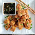 overhead shot of a white plate filled with finished Crispy Pan Fried Tofu with a side of dipping sauce