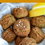 close up shot of finished Falafel in a parchment-paper lined bowl with lemon wedges on the side
