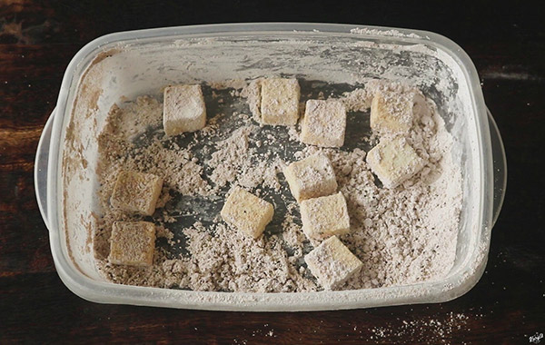 Crispy Pan Fried Tofu - Karyl's Kulinary Krusade overhead shot of tofu pieces in container with cornstarch mixture