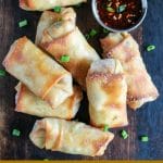 overhead shot of Crispy Baked Egg Rolls on serving board, with side of dipping sauce in top right hand corner