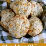 overhead shot of biscuits in a basket with a green and tan napkin