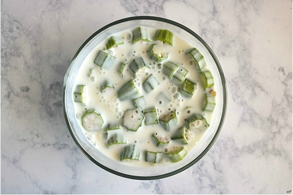 overhead process shot of okra marinating in buttermilk