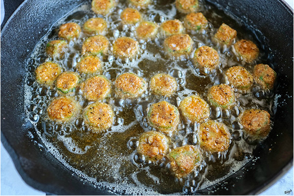 process shot of okra frying in a skillet