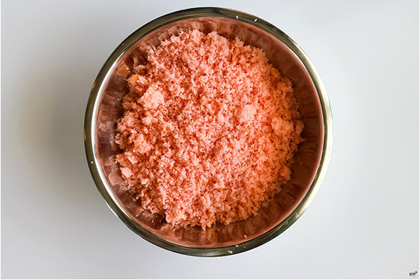 process shot: crumbled cake in a metal bowl