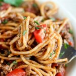 close up shot of finished taco spaghetti with a fork full of spaghetti above the bowl