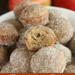 close up shot of a bowl of donut holes with one bitten in half