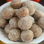 close up angled shot of donut holes in a white bowl