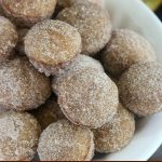 close up off-center shot of a bowl of finished donut holes win a white bowl