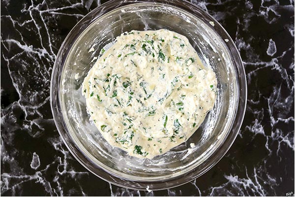 overhead process shot: spinach filling in a glass bowl