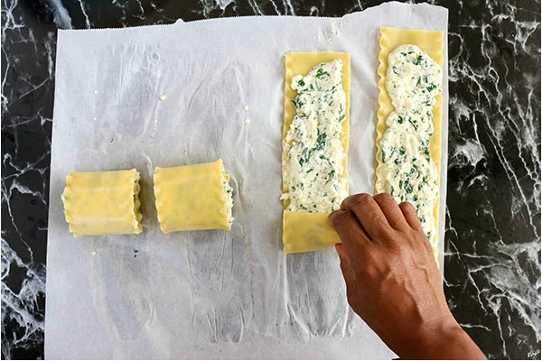 overhead process shot: rolling lasagna noodles into rolls
