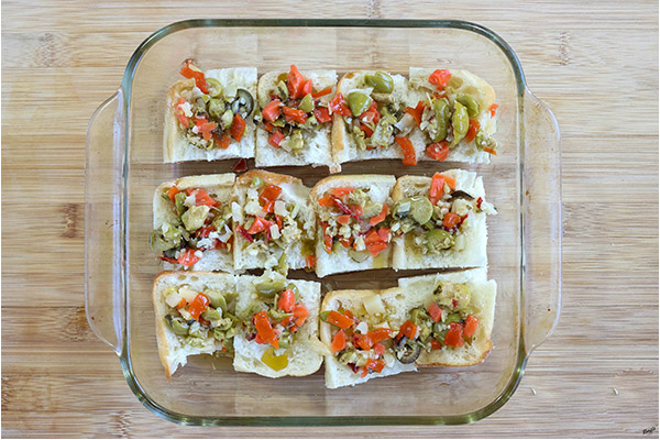 overhead process shot: olive salad on top of slider buns