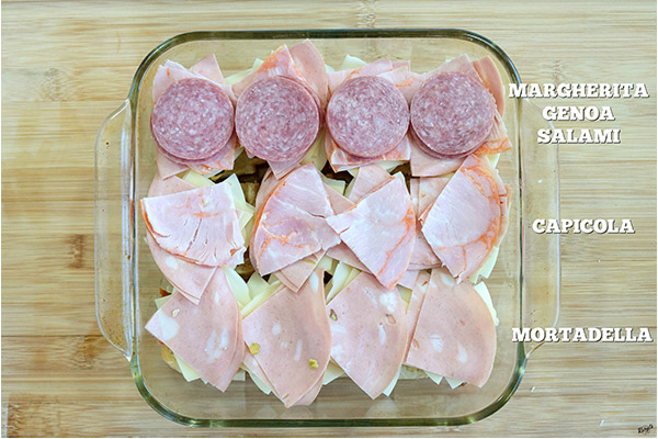 overhead process shot: Mortadella, Capicola and Genoa Salami layered on top of cheeses