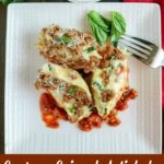 overhead shot of 3 stuffed shells on a white plate with a fork on the side
