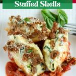 close up shot of 3 sausage spinach artichoke stuffed shells on a white plate