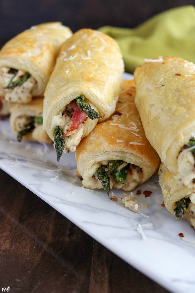 finished Asparagus Prosciutto Puff Pastry stacked on serving dish, open ends showing inside filling