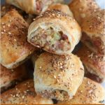 stack of finished sausage rolls with a side of mustard