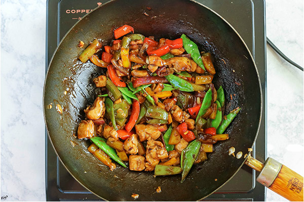 overhead process shot: all ingredients mixed together in a black wok