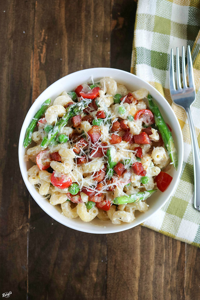 overhead shot of finished pasta in a white bowl with a fork on the side
