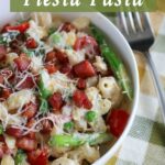 close up off center shot of a bowl of lemon ricotta fiesta pasta in a white bowl with a fork and napkin on the side