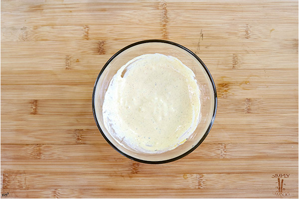 overhead process shot: dressing mixed together, in a glass bowl