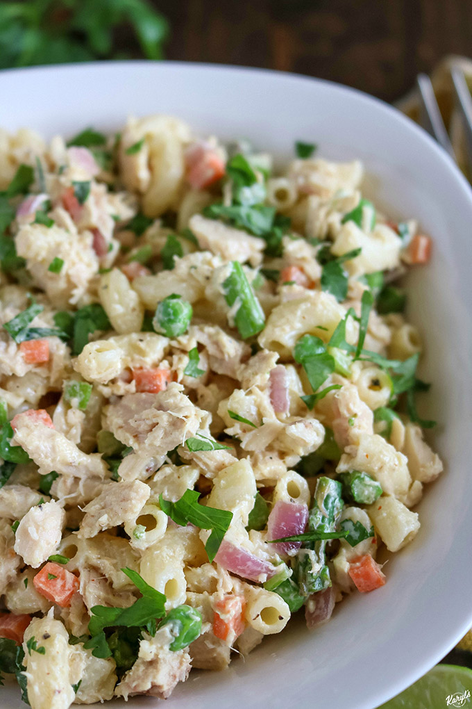 close up angled shot of finished tuna pasta salad in a white bowl