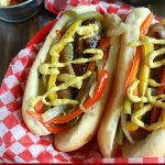 overhead shot of finished brats with mustard in a basket