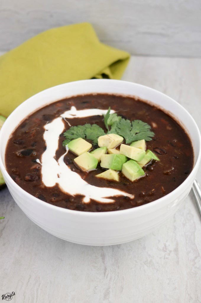 Close up shot of black bean soup in a white bowl
